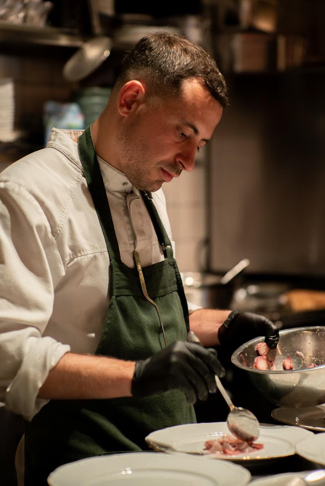 Chef Alejandro Torres plating a dish in the kitchen